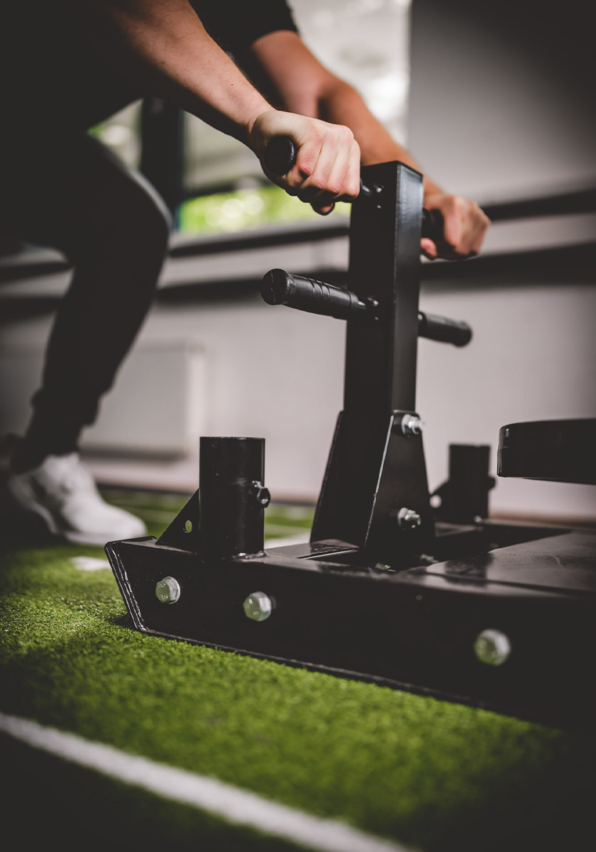 Frau schiebt Gewichteschlitten